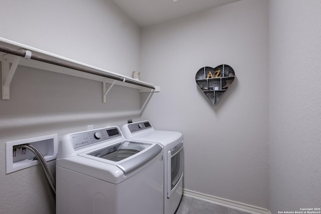 laundry room with tile patterned flooring, laundry area, washer and clothes dryer, and baseboards