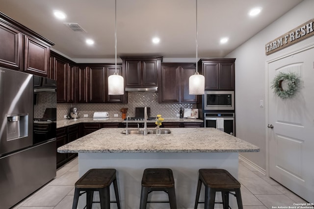 kitchen featuring appliances with stainless steel finishes, backsplash, a sink, and light tile patterned flooring