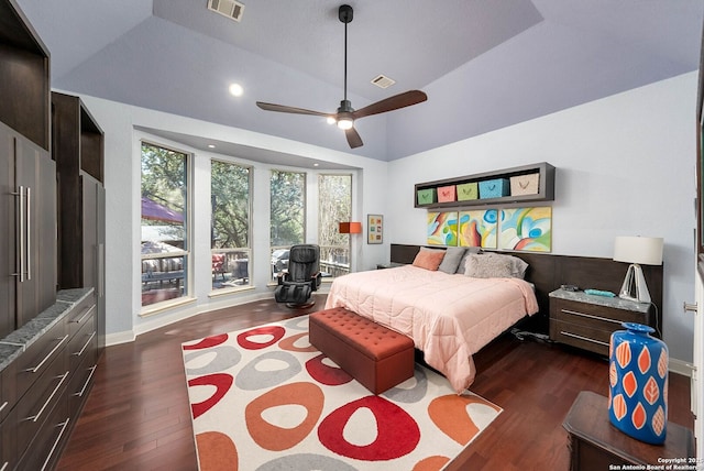 bedroom with dark wood-type flooring, lofted ceiling, visible vents, and a ceiling fan