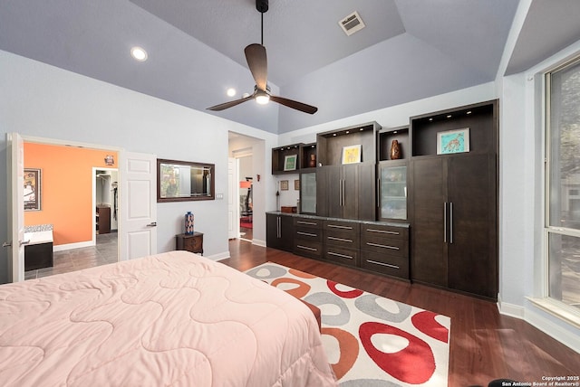 bedroom with lofted ceiling, baseboards, visible vents, and dark wood finished floors