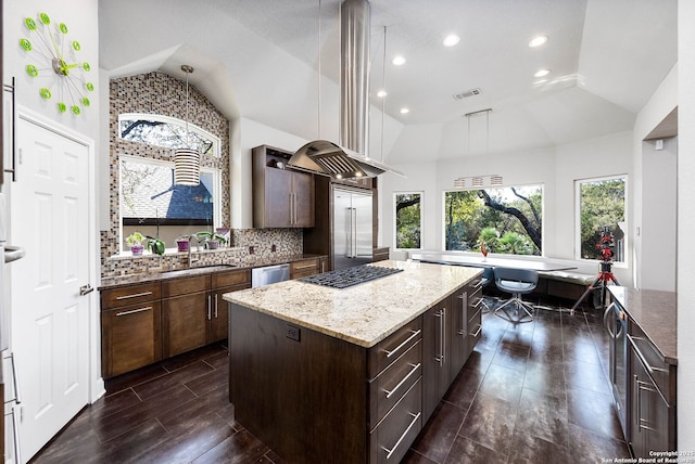 kitchen featuring tasteful backsplash, visible vents, a center island, stainless steel appliances, and a sink