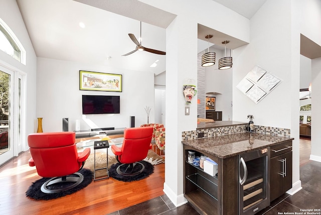 kitchen with dark brown cabinetry, beverage cooler, a ceiling fan, open floor plan, and dark wood-type flooring