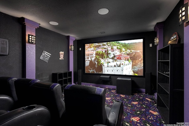 carpeted home theater room featuring ornate columns and visible vents