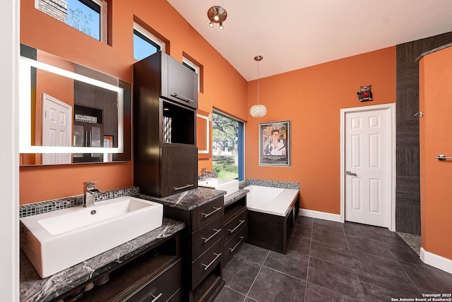 bathroom with a garden tub, baseboards, a sink, and tile patterned floors