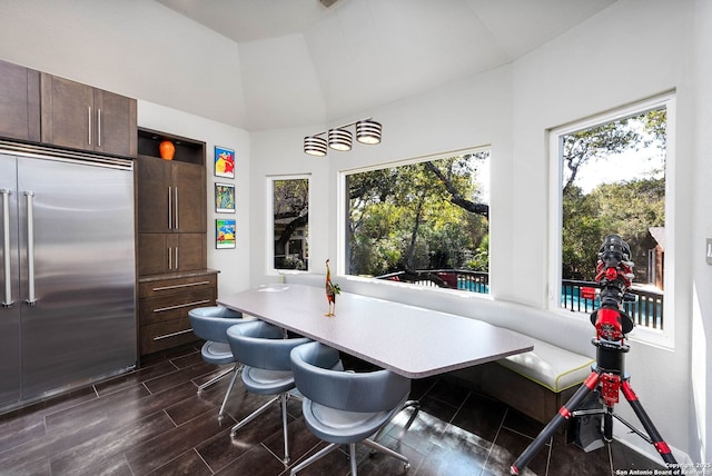 dining space with breakfast area, wood finish floors, and vaulted ceiling