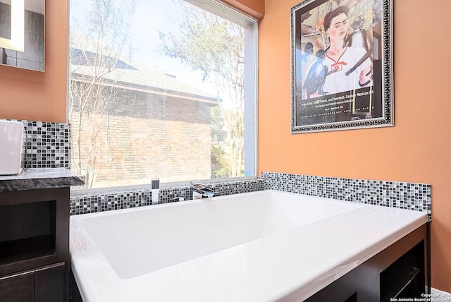 full bathroom with a bathtub, a healthy amount of sunlight, and a sink