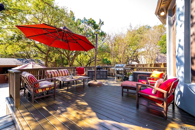 wooden deck with an outdoor hangout area and a grill