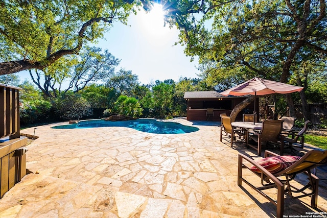 view of swimming pool featuring fence, outdoor dining area, a fenced in pool, and a patio