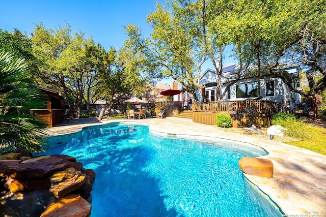 view of swimming pool featuring a deck, a patio area, fence, and a fenced in pool