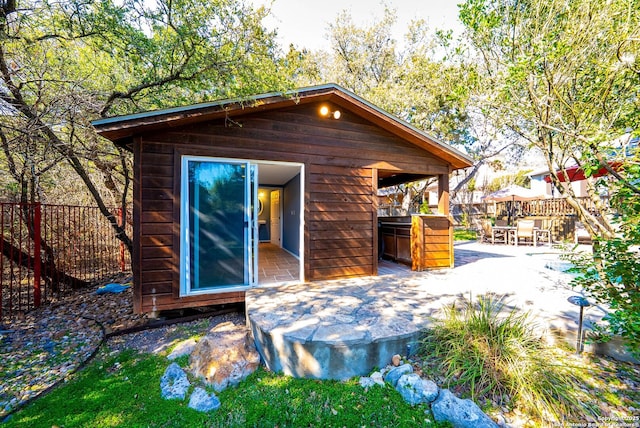 view of outbuilding with fence and outdoor dining area