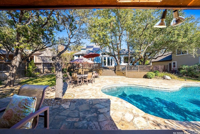 view of swimming pool with a patio, outdoor dining space, fence, and a fenced in pool