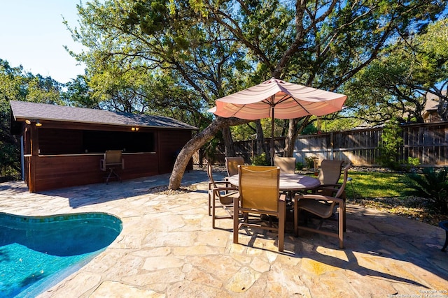 view of patio with a fenced in pool, outdoor dining area, and fence