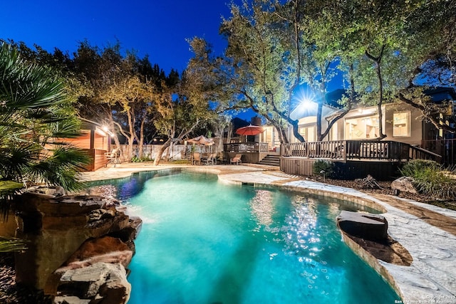 view of swimming pool featuring a wooden deck, a fenced in pool, and fence