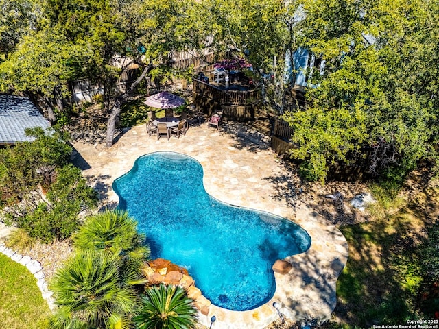 pool with a patio area and fence