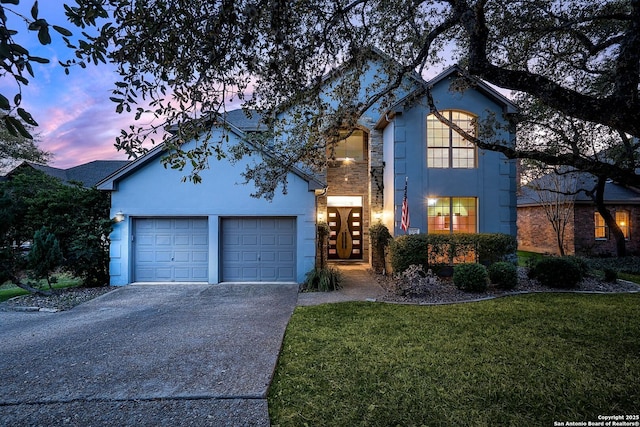 traditional-style house featuring stucco siding, concrete driveway, and a front yard