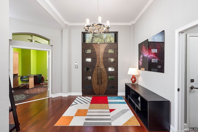 entrance foyer with baseboards, crown molding, an inviting chandelier, and wood finished floors