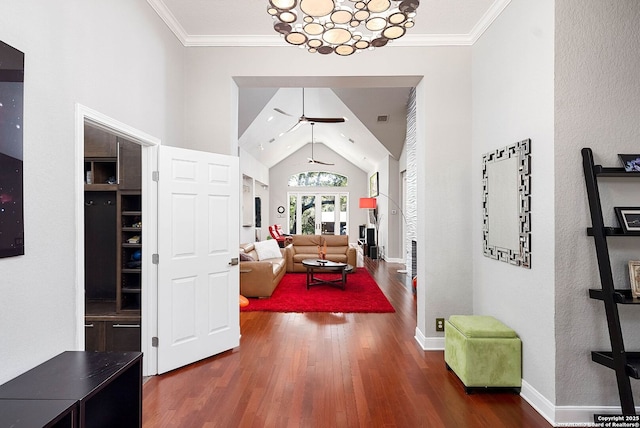 foyer entrance with baseboards, ornamental molding, vaulted ceiling, and wood finished floors