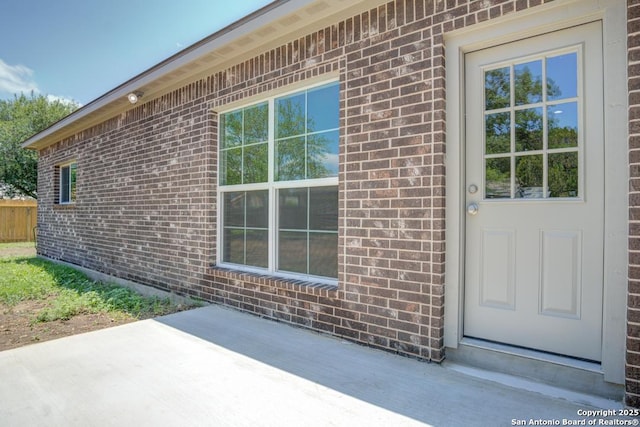 7903 Echo Wind, San Antonio, TX 78250 - view of exterior entry featuring brick siding and a patio