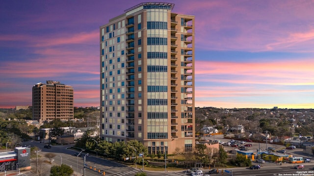 property at dusk featuring a city view