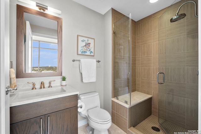 bathroom featuring a shower stall, toilet, and vanity