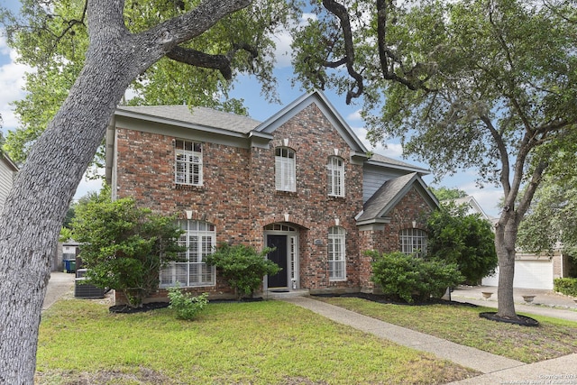 traditional-style home featuring brick siding and a front lawn