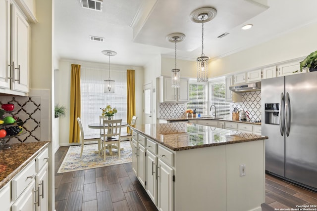 kitchen featuring visible vents, stainless steel fridge with ice dispenser, wood tiled floor, under cabinet range hood, and a sink