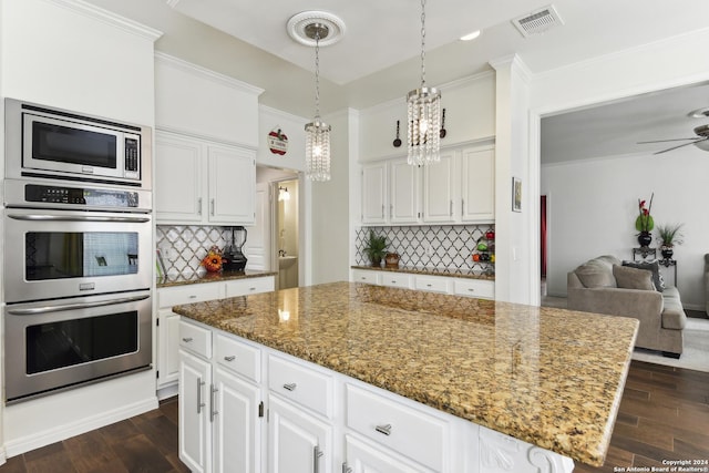 kitchen featuring stainless steel appliances, visible vents, dark wood finished floors, and light stone countertops