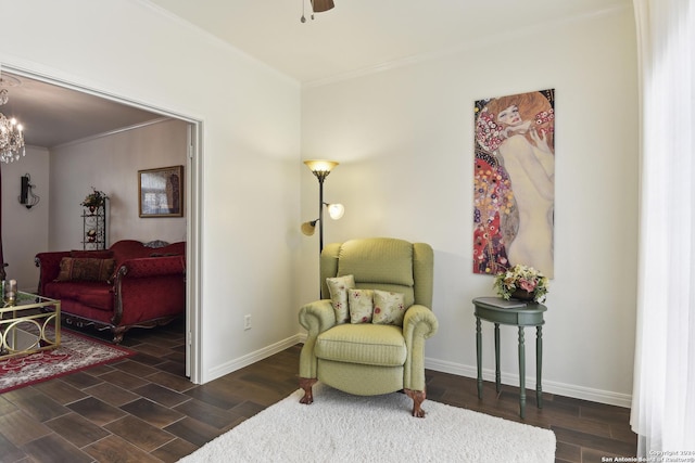 sitting room featuring ceiling fan with notable chandelier, crown molding, baseboards, and wood finished floors