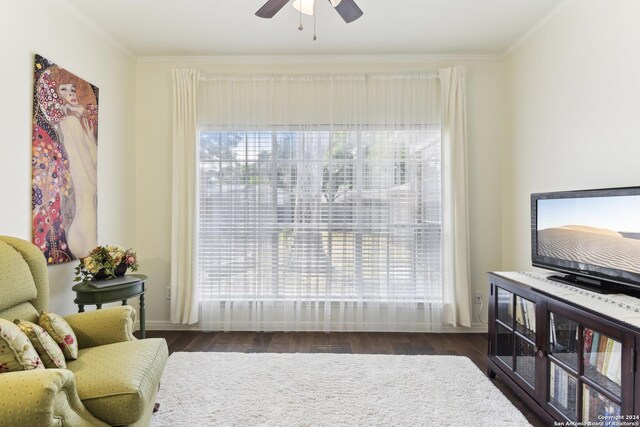 living area with crown molding, ceiling fan, and wood finished floors