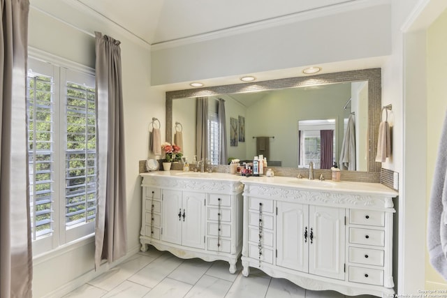 bathroom with lofted ceiling, tile patterned flooring, a wealth of natural light, and vanity