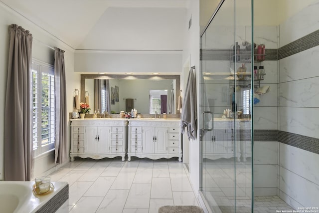 bathroom featuring a stall shower, vaulted ceiling, a sink, and double vanity