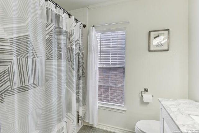 full bathroom featuring curtained shower, baseboards, vanity, and toilet