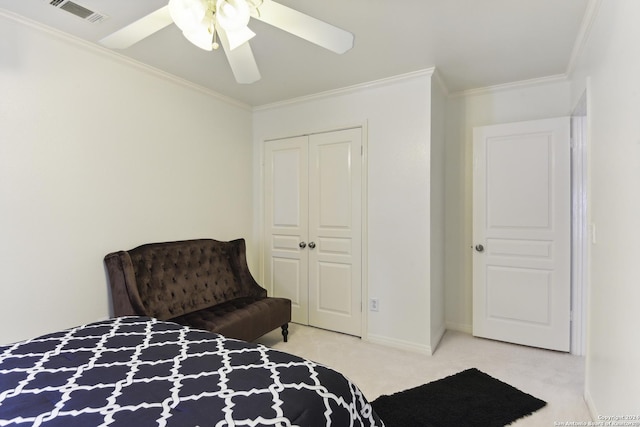 carpeted bedroom with baseboards, visible vents, ceiling fan, crown molding, and a closet