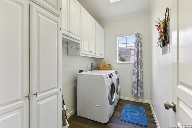 laundry area with cabinet space, baseboards, wood tiled floor, crown molding, and washing machine and dryer