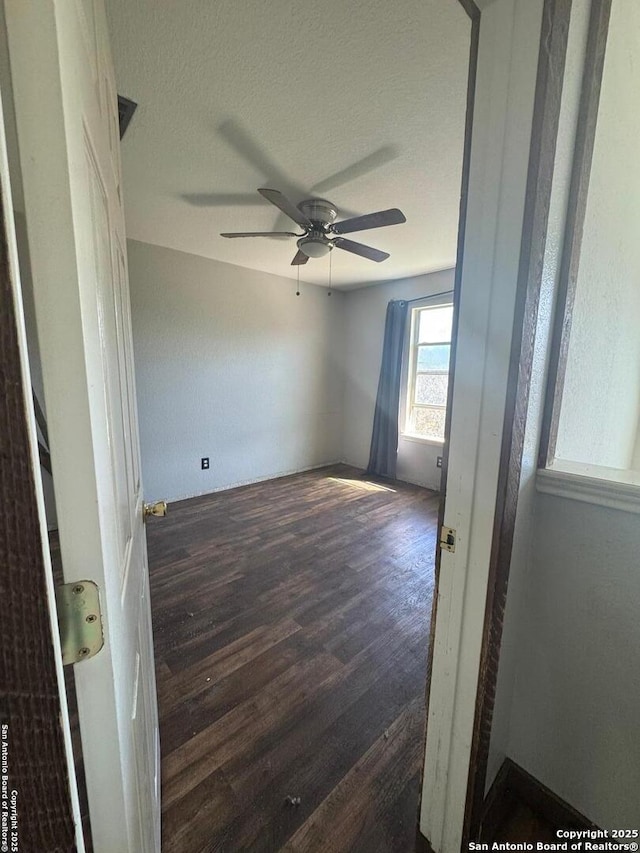 empty room with a ceiling fan, a textured ceiling, and wood finished floors