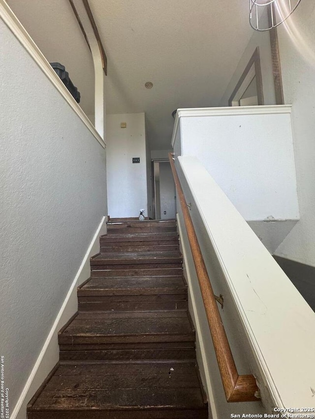 stairs featuring wood finished floors and baseboards