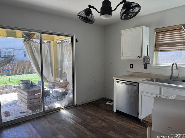 kitchen with a sink, white cabinetry, light countertops, stainless steel dishwasher, and dark wood finished floors