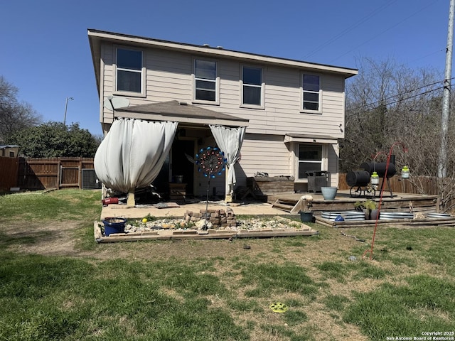 rear view of house featuring a lawn, a patio, and fence