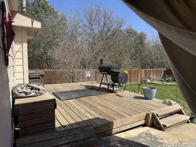 wooden terrace featuring a yard, a fenced backyard, and area for grilling