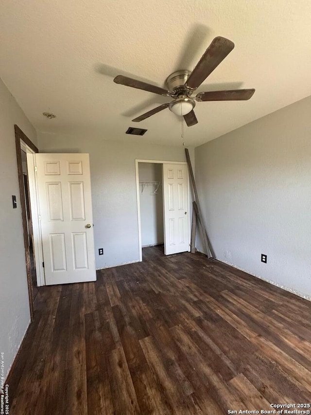 unfurnished bedroom with a closet, visible vents, a ceiling fan, a textured ceiling, and wood finished floors