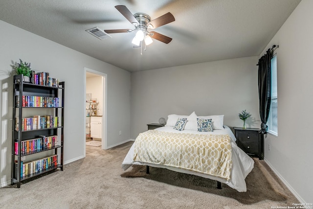carpeted bedroom with visible vents, baseboards, a ceiling fan, connected bathroom, and a textured ceiling