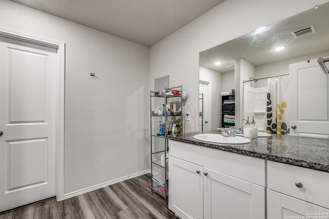 bathroom featuring wood finished floors, vanity, visible vents, baseboards, and a shower with curtain