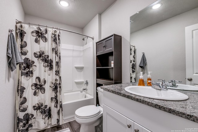 bathroom with a textured ceiling, toilet, shower / tub combo, wood finished floors, and vanity