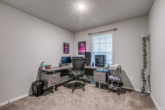 home office featuring a textured ceiling, carpet flooring, and baseboards