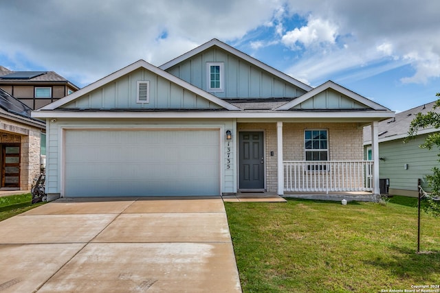 view of front of property with a garage, concrete driveway, covered porch, board and batten siding, and a front yard