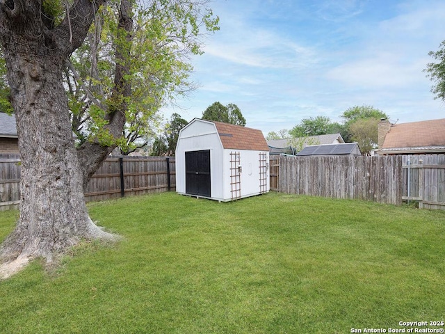 view of yard featuring a fenced backyard, an outdoor structure, and a storage shed