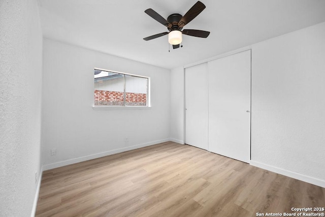 unfurnished bedroom with a ceiling fan, a closet, baseboards, and wood finished floors