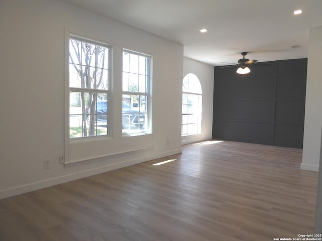 unfurnished room with a ceiling fan, recessed lighting, baseboards, and wood finished floors