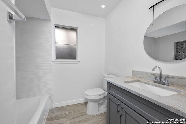 bathroom with vanity, toilet, and baseboards