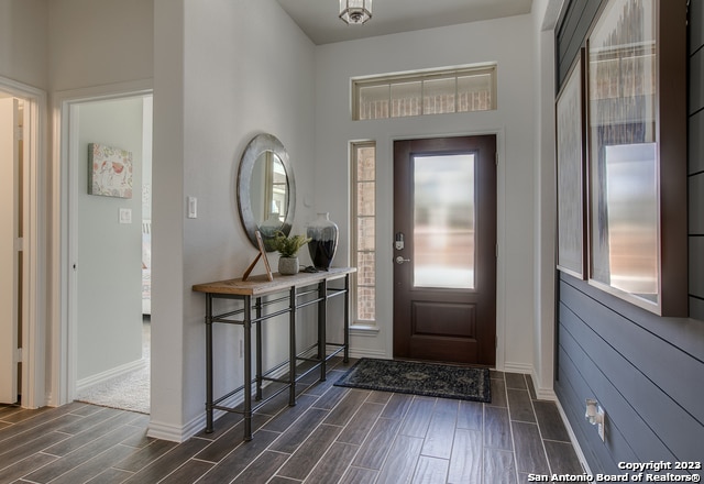 foyer with wood tiled floor and baseboards